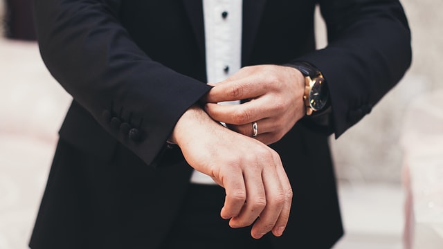 A man wearing a suit with a formal watch