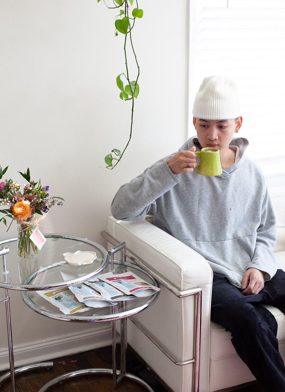 Student drinking a warm beverage with maca products nearby