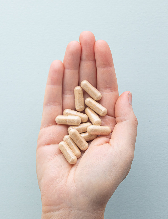 raw premium black maca pills in hand