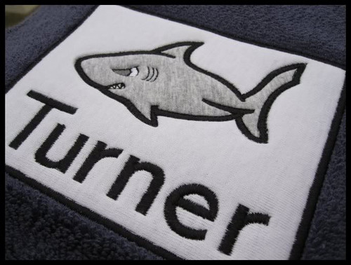 Picture of Applique Shark layered on a rectangle applique frame, stitched on a beach towel - Font is not included in this set.