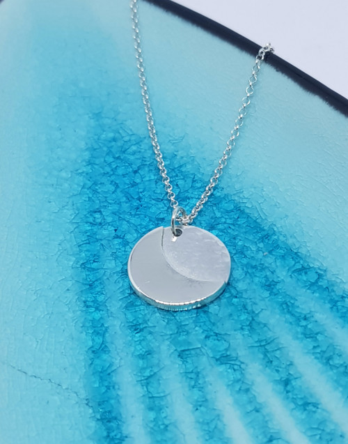 Our silver pendant is gently textured which represents the world and the high shine crescent is soldered directly to the world mirroring the bond of connection showing the love