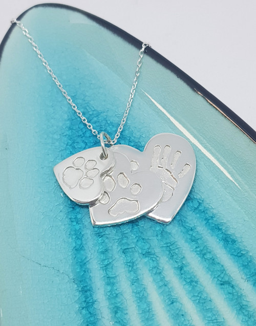 Sterling silver triple stacked paw print and hand print necklace in our elegant traditional heart shape