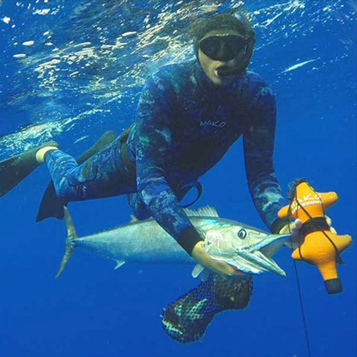 Spearfisher in deep blue water holding caught fish near yellow shark proof chum bag