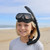 Child wearing MAKO Kids Snorkel with black mask and breathing tube on beach with ocean backdrop