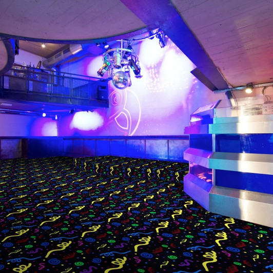 Joy Carpets Neon Lights Swirled Fluorescent 453 Commercial Broadloom Carpet Room Scene