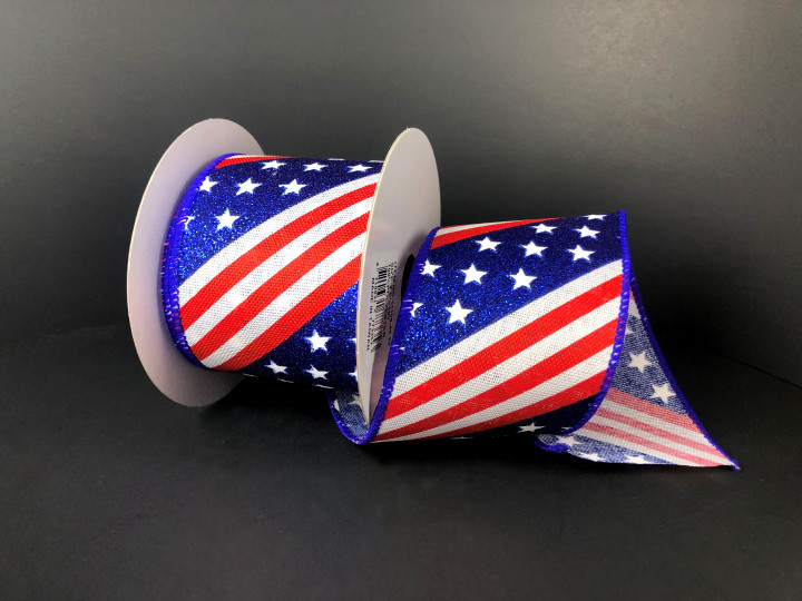 A 2.5 inch wide roll of patriotic wired ribbon featuring a diagonal pattern of glittery blue fields with white stars and red and white stripes on a poly-linen base.