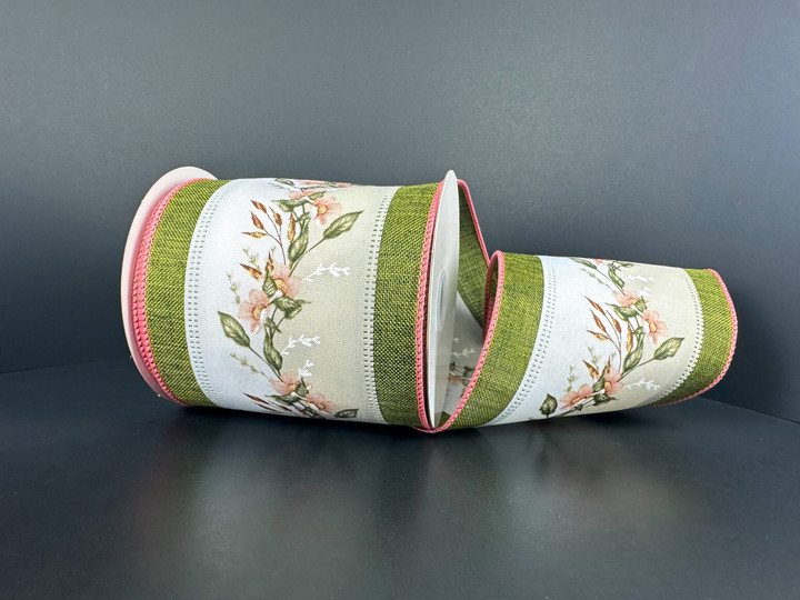 A 4 inch wide roll of poly linen wired ribbon featuring a center wildflower vine pattern flanked by moss green stripes and pink stitched edges.