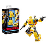 Transformers Devastation Bumblebee Transformers Studio Series, yellow robot action figure posed with a weapon, beside its packaging box.
