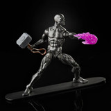 Marvel Silver Surfer with Mjolnir 6-inch Action Figure from the Avengers Marvel Legends Series, featuring a metallic silver figure holding Mjolnir, with a pink fireball in one hand, posed on a black surface against a black background.