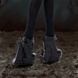 Monster High Wednesday Addams Monster High Wednesday Series Doll, close-up of the doll's legs wearing black knee-high socks and gothic-style black platform shoes with chunky heels and intricate detailing.