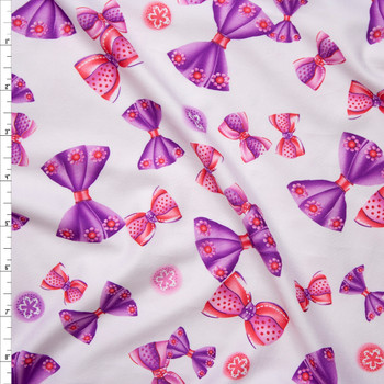 Pink and Purple Tossed Bows on Warm White Brushed Poly Spandex Fabric By The Yard