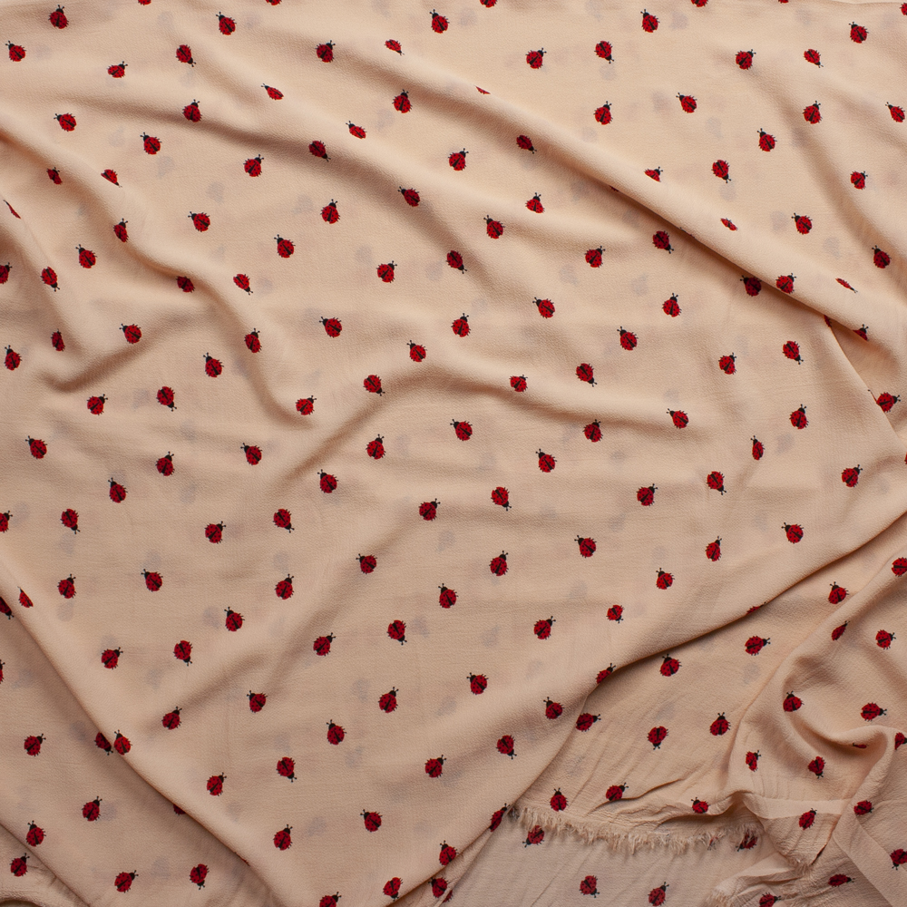 Ladybugs on Peach Bubble Crepe Fabric By The Yard - Wide shot
