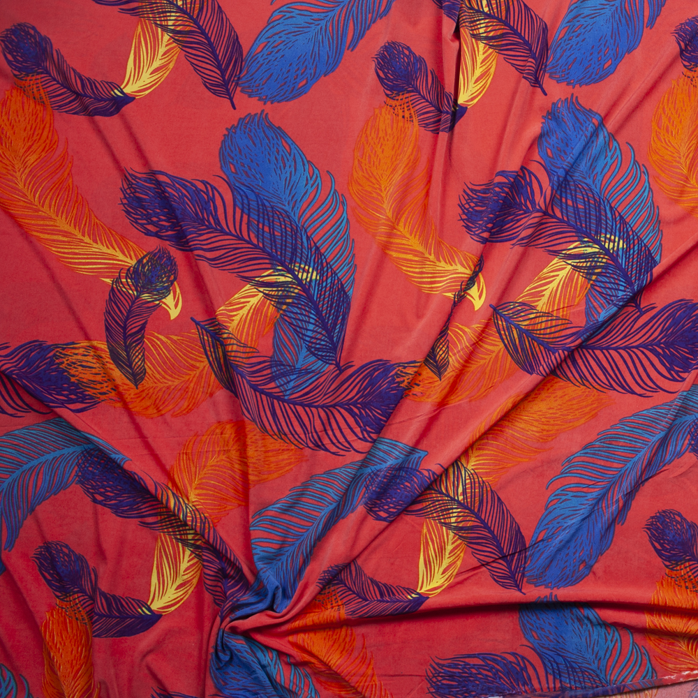 Turquoise, Blue, and Yellow Feathers on Neon Coral Poly/Spandex Knit Fabric By The Yard - Wide shot