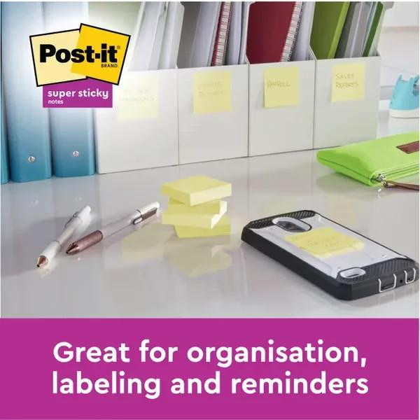 Post-it Super Sticky Notes 76x76mm Canary Yellow Promo Pack 90 Sheets per Pad, pack of 20 with 4 free, shown on a desk with pens, sticky notes, and organized files, ideal for organization, labeling, and reminders.