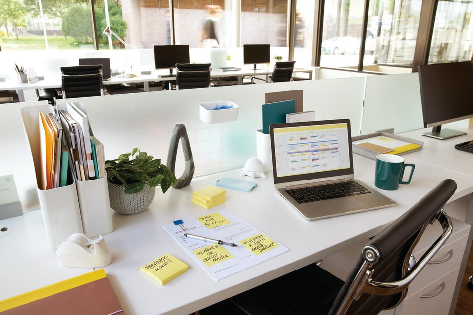 Post-it Notes 76x127mm 100 Sheets Canary Yellow, pack of 12, placed on a cluttered office desk with notebooks, a pen, and sticky notes for organization.