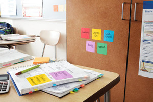 Post-it Super Sticky Notes Playful Colours 76x76mm 90 Sheets Pack 6, colorful notes on a classroom or office desk and attached to a bulletin board.