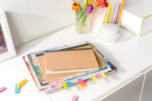 Post-it Note Paper Index Flags Repositionable, 15x50mm, assorted colors, pack of 500 tabs, on a white desk with notebooks and flowers.