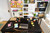 Post-it Super Sticky Z Notes Boost Colours 76x76mm 90 Sheets, pack of 5, bright multicolor sticky notes on a black desk in a vibrant office workspace.