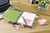 Post-it Post it Recycled Notes Assorted Colours 38x51mm 100 Sheets (Pack 24) 7100259447, a desk setup with colorful sticky notes, a notebook, pens, a laptop, and a glass vase with flowers.