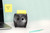 Post-it Z-Notes Dispenser Owl Black + 2 Packs Post-it Super Sticky Z-Notes 45 Sheets per Pad - 7100322315, an owl-shaped black dispenser with yellow sticky notes, placed on a white desk next to a laptop and a pen.