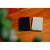 Various Verbatim Charge 'n' Go Essentials MagSafe Power Bank Wireless 10000mAh Black, two portable power banks placed on a wooden surface with blurred green plant in foreground.