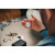 Various Verbatim MYFC-02BW My Finder Coin Bluetooth Item Finder 2 pack Black / White, close-up of a person holding the small, round tracking device in their hand with keys and other items in the background.