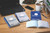 Product CW Office Challenge Trip Book 210X130MM PK5, assorted travel and notebook books on wooden desk with laptop, smartphone, pen, mug, and file organizer.