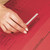 CW Office Rexel Filing/Clip 50MM Cap 70850 Bxd, a close-up image of a person's hand attaching a metal filing clip to a red file folder.