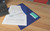 CW Office Eco Recyc Id Popp Wlt A4 AST PK5, blue document folder with a transparent cover holding papers and an index card on a wooden desk.