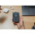 CW Office Verbatim Charge'n'Go 2C & Display MagSafe Power Bank 10000 mAh Grey, grey MagSafe power bank with circular wireless charging pad and display held in hand on a desk