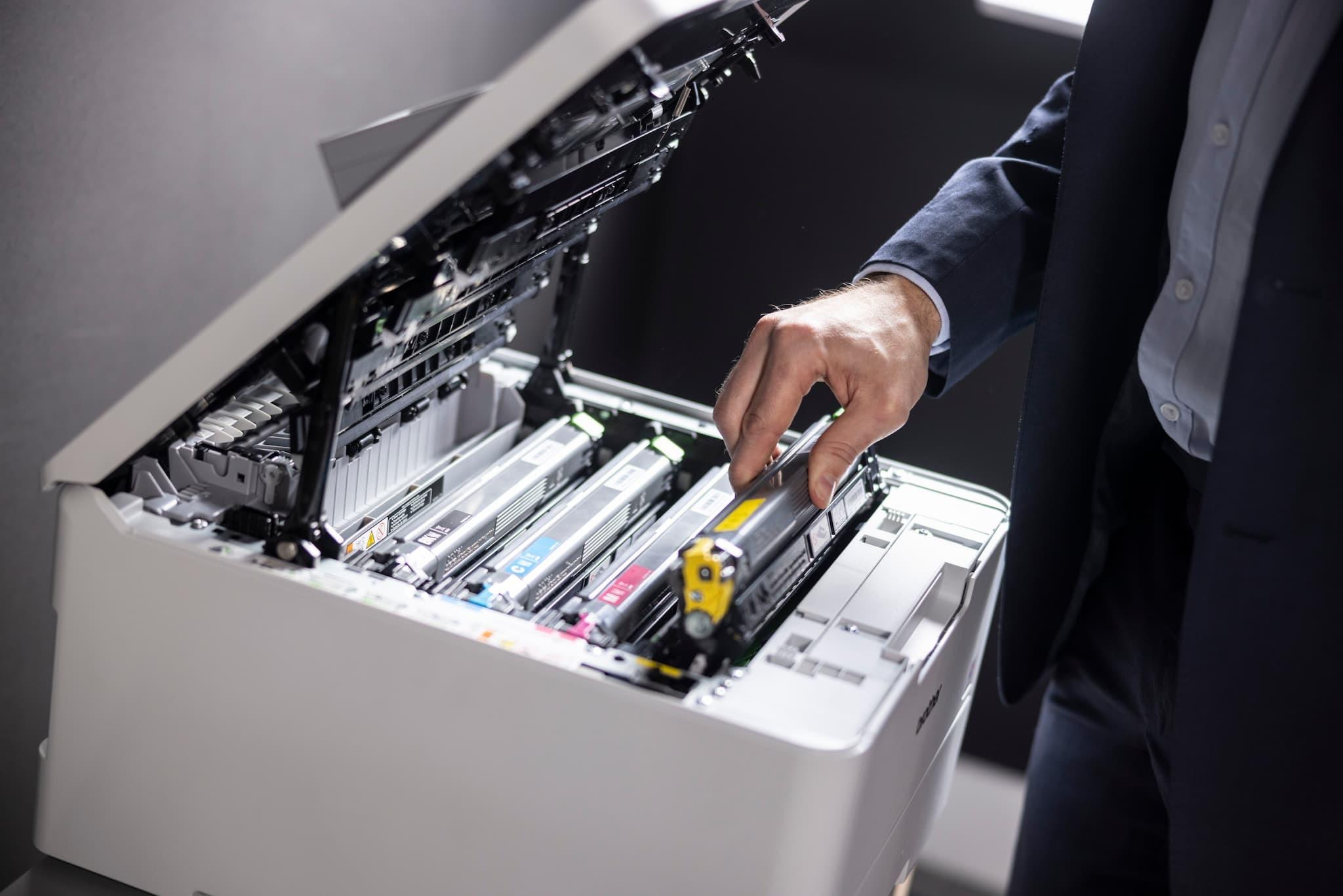 man putting toner cartridges in a printer
