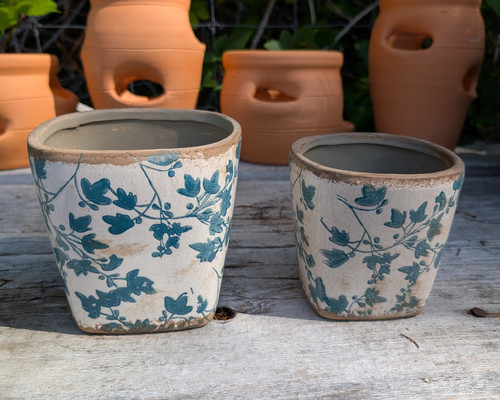 Set of two ceramic planters with blue botanical vine design.