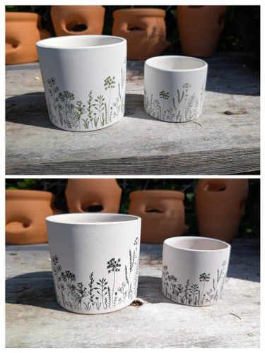White terracotta botanical planters available in black or green floral designs.