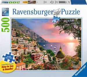 A puzzle with the words “Ravensburger Puzzle” at the top and the number ‘500’ along the left side of the white bordered cover. Below is an image of the finished puzzle, which features a high-up view of the sunset over an Italian village built into the side of a mountain. A small gulf with sail ships coming in for the night gives way to a vast expanse of sea, and the sun sets overhead, painting the sky with pinks and oranges. A puzzle with the words “Ravensburger Puzzle” at the top and the number ‘500’ along the left side of the white bordered cover. Below is an image of the finished puzzle, which features a high-up view of the sunset over an Italian village built into the side of a mountain. A small gulf with sail ships coming in for the night gives way to a vast expanse of sea, and the sun sets overhead, painting the sky with pinks and oranges.