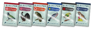 Expansion promo packs for a board game titled "Wingspan."  Each pack has an eggshell blue background, the name of the country of origin of the birds within the pack, a color-coded stripe, and a bird on the front.  The countries included are: Asia, Britain, Canada, Europe, New Zealand, and the USA.