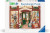 A puzzle with the words “Ravensburger Puzzle” and the number ‘1500’ along the top of the white bordered cover.  Below is an image of the finished puzzle, which features the facade of a bookshop called "Wordsmith's", as written in an arch above their green, open door.  Inside are paintings and prints of various literary references along the walls between shelves laden with books.  A tuxedo cat approaches the door with its tail high, and a staircase off to the right leads to an unseen upstairs.