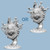 An unpainted beholder miniature in two variations with different eye stalks on a light blue background.