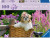 A puzzle with the words “Ravensburger Puzzle” at the top and the number ‘200’ along the left side of the cover.  Beside it is a puzzle piece with ‘XL’ inside, and the whole top of the cover has a thick, green rectangle.  Below is an image of the finished puzzle, which features a photograph of a Shih Tzu puppy sitting in a bike basket, its long hair held up in  a tie on the top of its head.  Behind is a field of tall, purple and pink flowers.