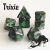 A set of 7 swirled black and grey, opaque polyhedral dice with green numerals and cats on one side instead of numbers.  In the bottom right corner is a cartoon of a stretching black and white cat whose mouth is open in a wide grin .