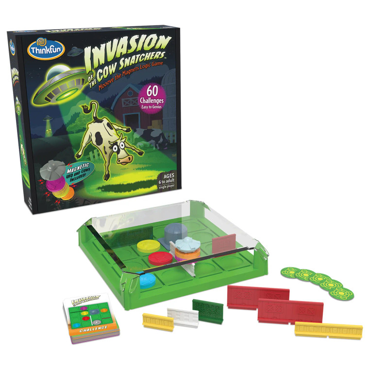 Board game box featuring game title and a cow floating up under a UFO in a green beam of light and various game components.