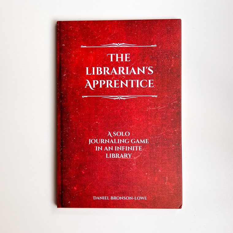 An RPG titled "The Librarian's Apprentice" in white font at the top of the red cover.  The booklet is designed to look like the cover of a leather or cloth-bound hardback book, and the title is bracketed in elegant lines for a distinguished finish.