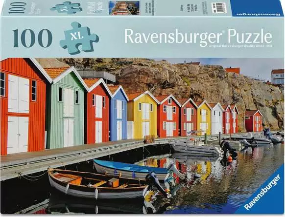 A puzzle with the words “Ravensburger Puzzle” at the top and the number ‘200’ along the left side of the cover.  Beside it is a puzzle piece with ‘XL’ inside, and the whole top of the cover has a thick, light blue rectangle.  Below is an image of the finished puzzle, which features a row of brightly colored red, blue, yellow, and green houses along a dock with boats tied to it.