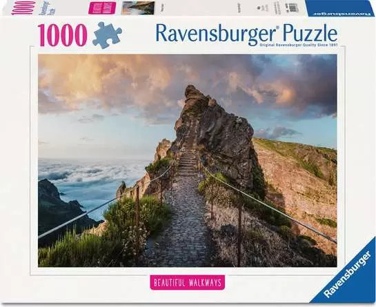 A puzzle with the words “Ravensburger Puzzle” at the top and the number ‘1000’ along the left side of the white bordered cover.  Below is an image of the finished puzzle, which features a photograph of a path along the side of a mountain, with the end reaching the highest peak.  Behind is a sunrise dotted with clouds and the distant stretch of the rest of the mountain range.