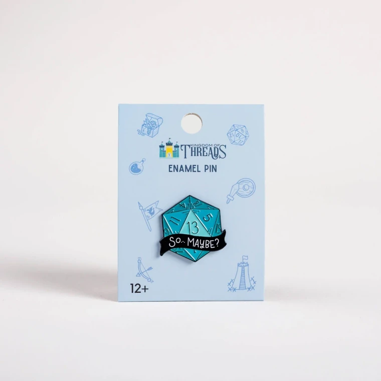 An enamel pin featuring a large, blue 20-sided die with a black banner across the center and white text that reads, "So... Maybe?"