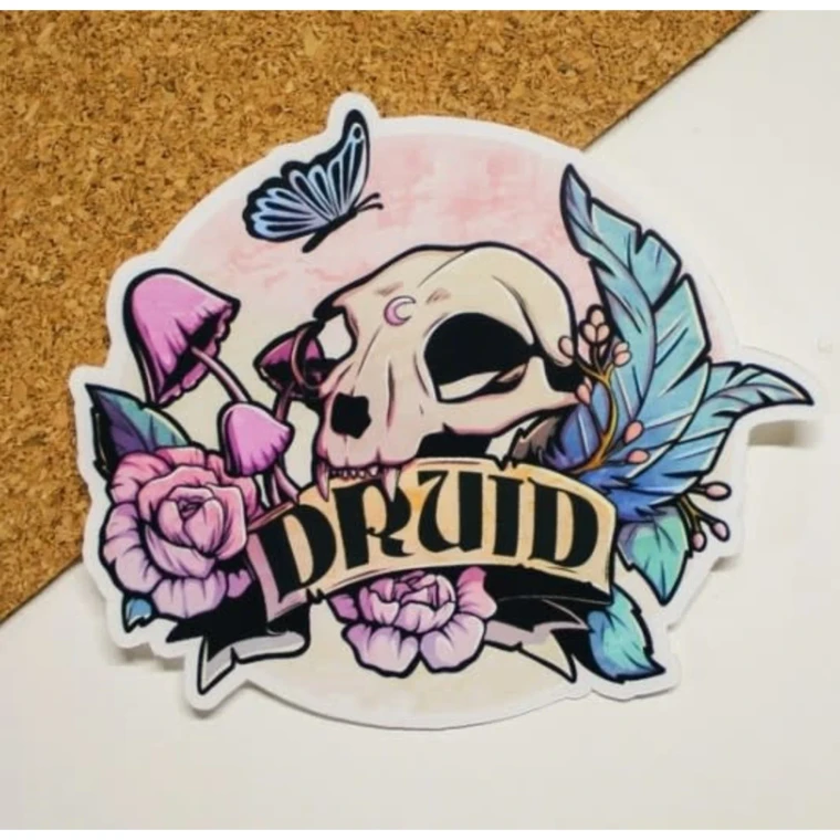 A vinyl sticker featuring a carnivorous animal's skull that has a moon engraved on its forehead.  Around it are large rose heads, small berries, long leaves, and mushrooms.  Below is a scroll that reads, "Druid," in large, black font.