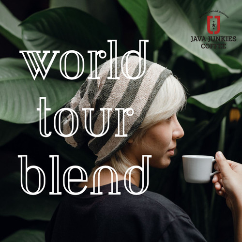 Java Junkies World Tour Blend Coffee. Woman standing under an Elephant Ear Plant drinking a small cup of coffee and has a black shirt on.