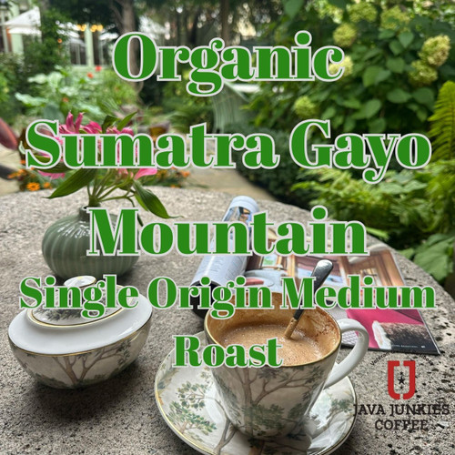 Organic Sumatra Gayo Mountain Fair Trade. Elegant jungle coffee setting with a coffee cup full of creamy coffee and forest in the background.