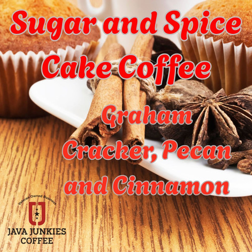 Java Junkies Sugar and Spice Cake Cupcakes. Two large cupcakes with cinnamon stick and cloves sitting between them on a light brown wooden table.