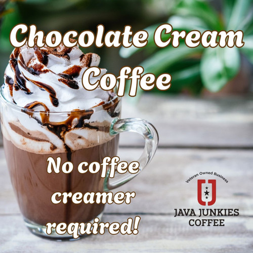 Java Junkies Chocolate Cream Coffee. Creamy coffee topped with whipped cream and chocolate drizzle on a picnic table.