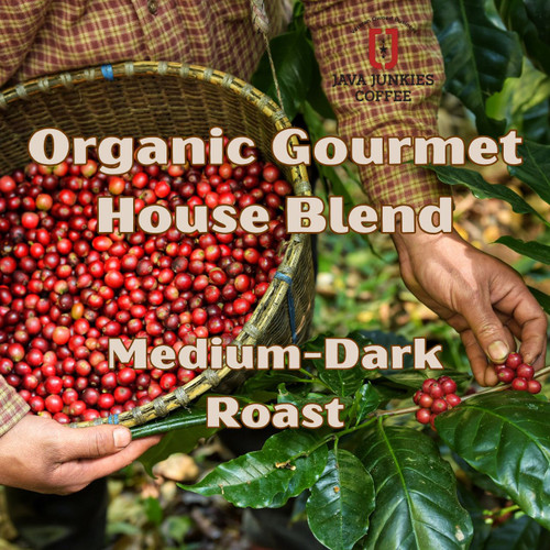 Java Junkies Organic Gourmet House Blend Coffee. Woven basket full of red coffee cherries being held by a person harvesting them.